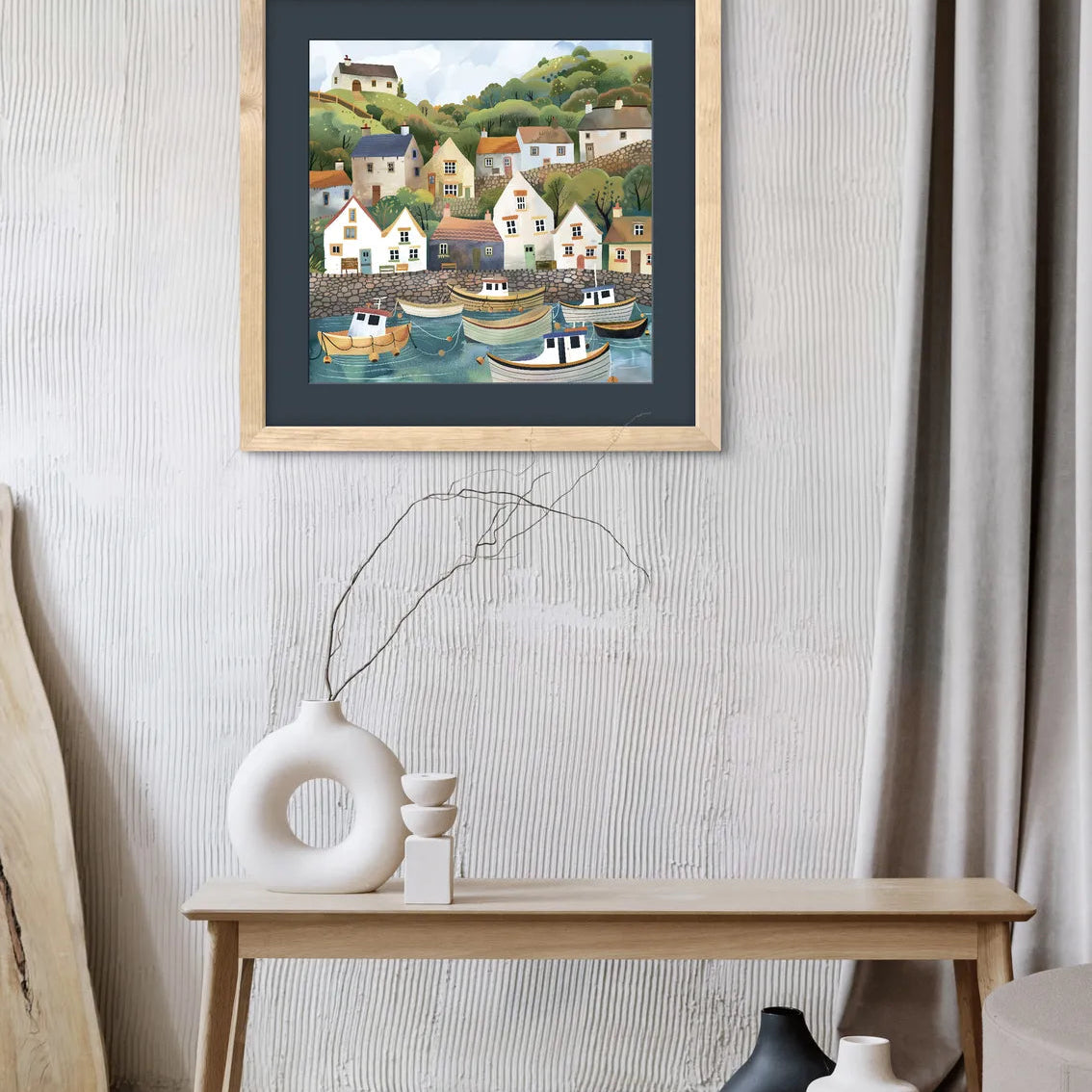 Artwork depicting a quaint coastal village with colourful houses and boats in a harbour.