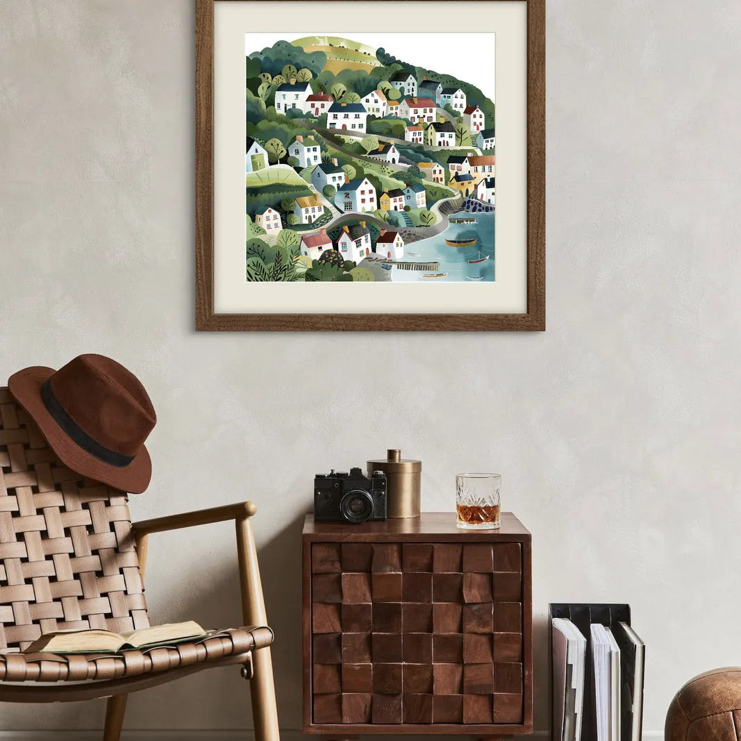 Colourful illustration of a coastal village on green hills with trees and boats.