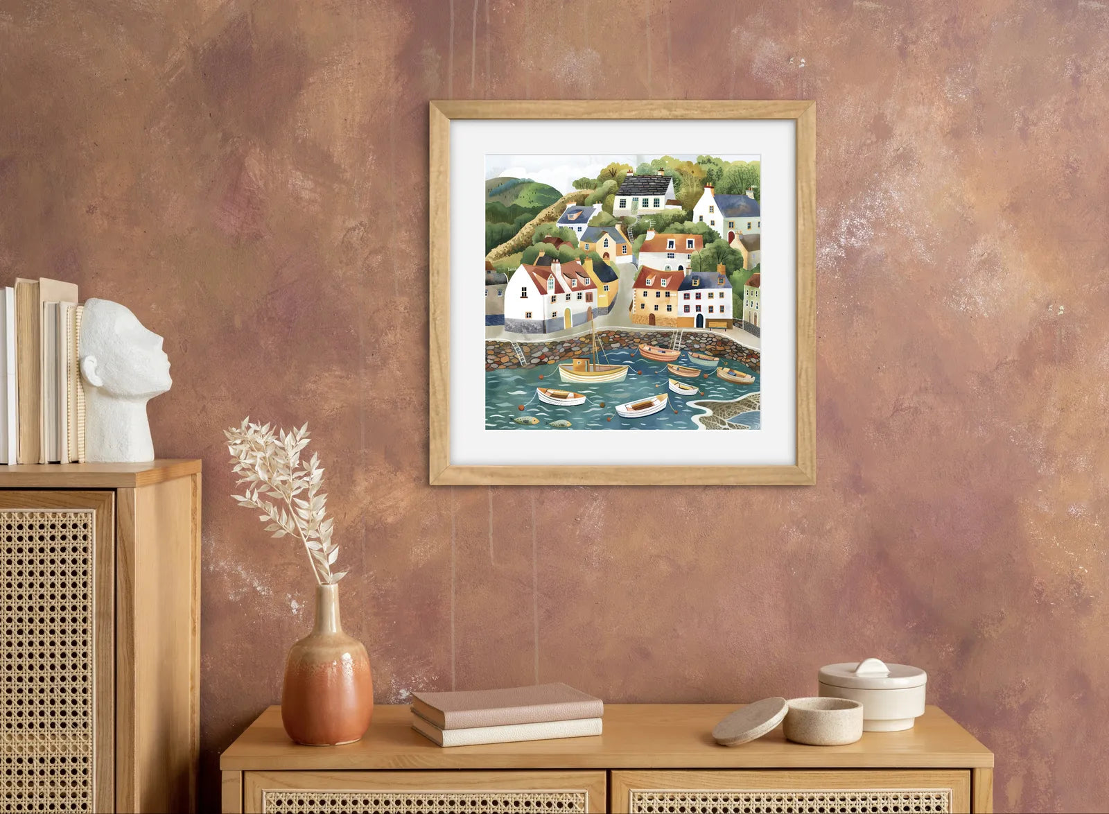 Artwork of a colourful coastal village with cottages and boats in a harbour.